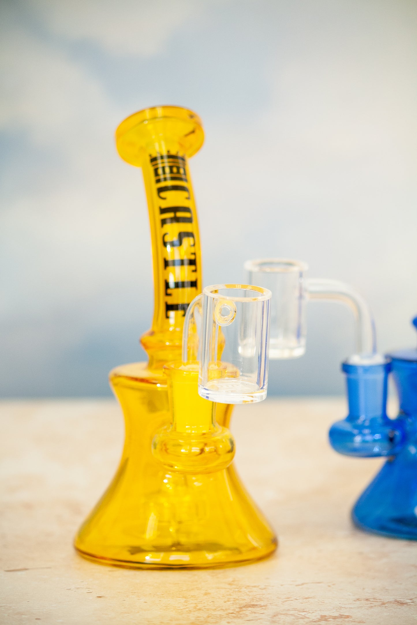 Bright yellow dab rig with clear glass banger.